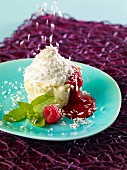 Vanilla ice cream with raspberry sauce, cream and grated coconut