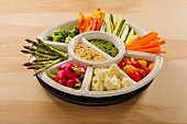 Hummus and pesto dip with raw vegetables in bowls