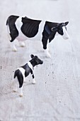 A plastic toy cow and a calf