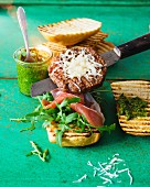 An Italian burger with Parma ham, pesto and rocket