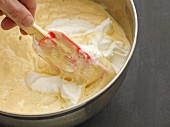 Beaten egg whites being folded into cake mixture