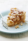 A slice of apple tart with coconut crumbles