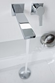 Fliessendes Wasser aus Wandarmatur mit kantigem Design