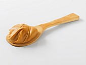 A dollop of peanut butter on a wooden spoon