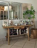 Rustic console table with small wine rack below three bevelled mirrors