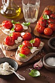 Bruschetta topped with roasted tomatoes, cream cheese and basil