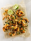 Lime and herb prawns with spring onions, peanuts, parsley, garlic and cracked pepper on parchment paper