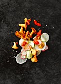Chanterelle mushrooms with sliced radish and horseradish, cucumber and red pesto