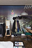 Teenager's bedroom with desk, clothes racks and cityscape mural wallpaper
