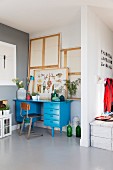 Blue-painted desk and retro chair in niche