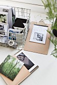Postcards in wire basket next to blotter and tablet PC in case