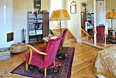 Fifties armchair, side table and standard lamp on rug in front of tiled stove