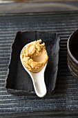 Miso paste on a spoon in a rustic dish
