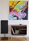 Modern painting above retro hifi cabinet with records in shelf compartment