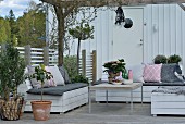 Comfortable seating area with DIY outdoor furniture on Scandinavian-style terrace