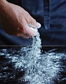 Flour being sprinkled onto a work surface
