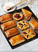Flaky pastry jam turnovers on a baking tray