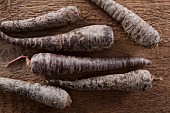 Black carrots on a wooden surface