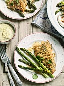 Trout with a herb coating with mustard mayonnaise and grilled asparagus