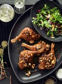 Goose legs with a walnut glaze and a herb salad with pomegranate seeds