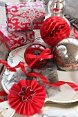Christmas baubles and gifts on plate in shades of red, silver and white
