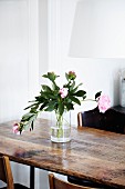 Pink peonies in glass vase on wooden table