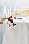 Weihnachtlich gedeckter Tisch mit Weihnachtsdeko, Wein und Kerzen