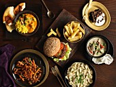 Buffet mit Hamburger, Pommes frites, Nudelgericht, Rindfleischgericht, grünes Thai-Hähnchencurry, indisches Hähnchencurry und Brownie
