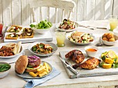 Sommerbuffet mit Rucola- und Reisnudel-Hähnchen-Salat, Reisbällchen, Grillhähnchen, Hamburger, Ratatouille, Hähnchencurry und Gemüsekuchen