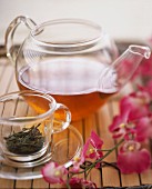 Grüner Tee in Glaskanne, Teeblätter in Glastasse
