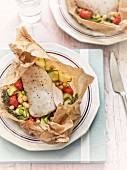 Fish with courgettes, chickpeas and tomatoes in parchment paper