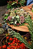 Autumn wreath of sedum, hydrangea & leaves on garden table