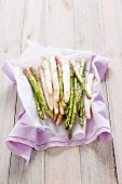 Green and white asparagus on a purple cloth
