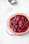 Käsekuchen-Souffle mit roten Früchten (Erdbeeren, Heidelbeeren, Kirschen, Granatapfelkerne und rote Pflaumen)