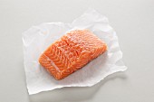 A fresh salmon fillet on a piece of paper