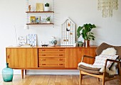 Fifties wooden sideboard and sheepskin rug on armchair