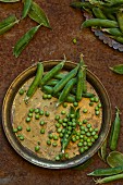 Peas and pea pods on a vintage metal plate