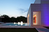 Twilight atmosphere; pool and spherical lamps outside contemporary house