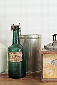 Vintage, swing-top bottle next to old-fashioned coffee mill and tin