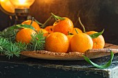 Clementines with leaves on a piece of cork