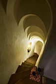 View down steep stone stairs with stepped, arched ceiling