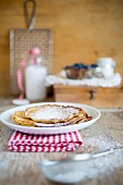 A stack of pancakes dusted with icing sugar