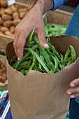 Green beans in a paper bag at a market