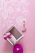 Top view of bras on pink armchair and fuchsia side table on pink rug with white floral pattern