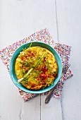 An omelette with cherry tomatoes and spring onions