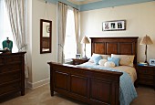 Traditional bedroom with accessories and pale blue frieze combined with dark wooden furniture