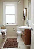 Narrow, traditional bathroom in renovated period building; modern washstand with sink protruding over floating base unit