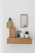 Wooden boxes of various shapes and sizes hung on wall around mirror