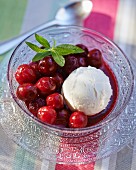 Hot cherries with a scoop of almond ice cream in a dessert bowl