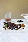 Broken dark chocolate with salted caramel, fresh blueberries and a glass of chocolate milk